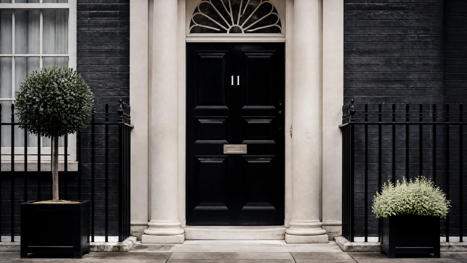A glossy black Georgian door bearing the numeral eleven